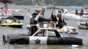 Left to right, Cameron Gembla, Tim Zableckis, Brandon Dobe, and Rodney Shipe paddle their Blues Brothers-themed boat in the Cedar Lake Summerfest. (Cedar Lake Summerfest, Handout)
