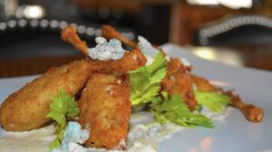 The new Hache Moderne Brasserie on State Street in Geneva offers an exciting twist on traditional French cuisine. Pictured here is the buffalo frog legs, topped with whipped Gorgonzola and celery leaves. (Beth Casey / Beacon-News)